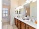 Bathroom featuring a double vanity, soaking tub, and separate toilet area at 11031 Sw 69Th Cir, Ocala, FL 34476