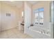 Bright bathroom with marble tub, double faucet, and ample natural light from the large window at 11031 Sw 69Th Cir, Ocala, FL 34476