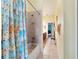 Bathroom featuring a bathtub with shower and cat shower curtain and neutral tile flooring at 11031 Sw 69Th Cir, Ocala, FL 34476
