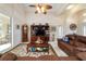 Cozy living room with tray ceiling, ceiling fan, and sliding glass doors leading to the lanai at 11031 Sw 69Th Cir, Ocala, FL 34476