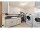 Laundry room with washer, dryer, and storage cabinets at 3261 Se 32Nd St, Ocala, FL 34471