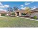 Charming brick home featuring a manicured lawn, mature landscaping, and inviting walkway at 407 Soft Shadow Ln, Debary, FL 32713