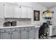 Kitchen with office nook featuring modern gray cabinets and stone backsplash at 407 Soft Shadow Ln, Debary, FL 32713