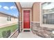 Inviting front porch with a red door, stone accents, and screened enclosure at 9664 Sw 76Th Lane Rd, Ocala, FL 34481