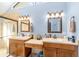 Bathroom featuring dual sinks, vanity area, large mirrors, and glass-enclosed shower at 2922 Se 38Th Pl, Ocala, FL 34480