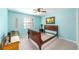 Bedroom with light blue walls, neutral carpet, and a painting above a sleigh bed at 2922 Se 38Th Pl, Ocala, FL 34480