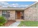 Close up shot of a home's entrance showing the brick facade and the stained wood front door at 2922 Se 38Th Pl, Ocala, FL 34480