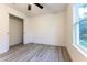 Neutral bedroom featuring wood-look floors and closet, with a view of the outdoors through the window at 11 Locust Terrace Way, Ocala, FL 34472