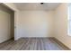 Neutral bedroom featuring wood-look floors and closet, with a view of the outdoors through the window at 11 Locust Terrace Way, Ocala, FL 34472