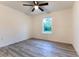 Bright bedroom with wood-look floors, a ceiling fan, and a window for natural light at 11 Locust Terrace Way, Ocala, FL 34472