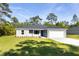 Single-story home with a fresh gray exterior, green lawn and a bright blue front door at 11 Locust Terrace Way, Ocala, FL 34472