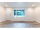 Open living space featuring hard surface floors, neutral walls, a window and a white door at 11 Locust Terrace Way, Ocala, FL 34472