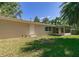 View of the backyard of a tan colored home with a screened in porch at 2060 Se 39Th St, Ocala, FL 34480