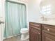 Cozy bathroom with a shower behind a striped curtain, a toilet, and a vanity with dark cabinets at 2060 Se 39Th St, Ocala, FL 34480