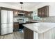 Modern kitchen featuring stainless steel appliances, granite countertops, and dark wood cabinets at 2060 Se 39Th St, Ocala, FL 34480