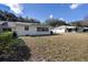 Spacious backyard featuring an open lawn and an adjacent light colored home exterior at 9691 Sw 95Th Ct # A, Ocala, FL 34481