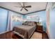 Cozy bedroom with a ceiling fan, dark wood floors, and blue walls at 9691 Sw 95Th Ct # A, Ocala, FL 34481