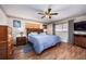 Cozy bedroom featuring a wood-trimmed headboard, ceiling fan, and warm, wood-look flooring at 9691 Sw 95Th Ct # A, Ocala, FL 34481