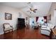 Bright living room with hardwood floors, ceiling fan, modern furnishings, and a clear view of the front entrance at 9691 Sw 95Th Ct # A, Ocala, FL 34481