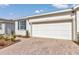 Close-up of white garage door with brick driveway, tidy landscaping, and blue shutters at 5341 Nw 48Th Pl, Ocala, FL 34482