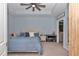 Relax in this blue-hued main bedroom with a ceiling fan, tray ceiling, and ensuite bathroom at 5341 Nw 48Th Pl, Ocala, FL 34482