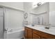 Bathroom features dual sinks, wood cabinets, a soaking tub, and a decorative mirror at 2251 Oakington St, Winter Garden, FL 34787