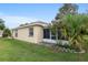 A beautiful backyard, and exterior view of the home's tan stucco siding and screened-in porch at 9481 Sw 93Rd Loop, Ocala, FL 34481