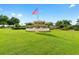 Well-manicured community green space with the American flag in front of a beautiful amenity center at 9481 Sw 93Rd Loop, Ocala, FL 34481