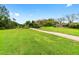 Expansive community green space with a paved walkway leading towards a community center or amenity building at 9481 Sw 93Rd Loop, Ocala, FL 34481