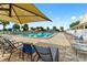 The inviting pool area with palm trees is surrounded by lounge seating under sun umbrellas at 9481 Sw 93Rd Loop, Ocala, FL 34481