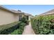 Well-manicured hedges line the walkway of this home, providing privacy and adding to its charm at 9481 Sw 93Rd Loop, Ocala, FL 34481