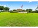 Expansive green lawn and landscaped grounds with an American flag waving proudly in front of the residential building at 9481 Sw 93Rd Loop, Ocala, FL 34481