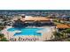 Aerial view of the community pool and clubhouse, with chairs and umbrellas for relaxing and enjoying the outdoors at 9481 Sw 93Rd Loop, Ocala, FL 34481