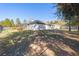 View of a large backyard featuring a black metal fence, shrubbery, and a screened-in pool at 12880 Sw 66Th St, Ocala, FL 34481