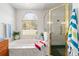 Bright bathroom featuring a marble tub under a large window and a glass-enclosed shower at 12880 Sw 66Th St, Ocala, FL 34481