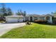 Beautiful single-story home featuring a manicured lawn, three-car garage, and well-maintained landscaping at 12880 Sw 66Th St, Ocala, FL 34481