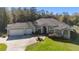 Inviting single-story home featuring a well-manicured lawn, three-car garage, and mature landscaping at 12880 Sw 66Th St, Ocala, FL 34481