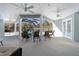 The covered patio features tile flooring, ceiling fans, ample seating, and access to the screened pool area at 12880 Sw 66Th St, Ocala, FL 34481