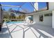 A sparkling pool with a waterfall feature and a spacious patio is surrounded by a screened enclosure at 12880 Sw 66Th St, Ocala, FL 34481