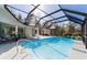 An inviting inground pool with ample deck space is surrounded by a screened enclosure and landscaping at 12880 Sw 66Th St, Ocala, FL 34481