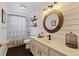 Stylish bathroom with shiplap walls, round mirror, and updated sink and vanity at 1762 Ne 39Th St, Ocala, FL 34479