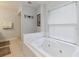 A close up of a bright white bathroom with a large bathtub and tile flooring at 906 Crestview Dr, Auburndale, FL 33823