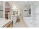 Large bathroom features dual sinks, a soaking tub, and neutral colors at 906 Crestview Dr, Auburndale, FL 33823