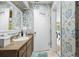 Bathroom with floral wallpaper, wood vanity, and a view of the backyard pool at 906 Crestview Dr, Auburndale, FL 33823