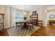 Dining room features a round wood table, decorative chandelier, and beautiful hardwood floors with a patterned rug at 906 Crestview Dr, Auburndale, FL 33823