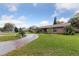 Lush landscaping with circular driveway leading up to a beautiful brick home at 906 Crestview Dr, Auburndale, FL 33823