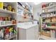 Functional laundry room with appliances and ample shelving for storage and supplies at 906 Crestview Dr, Auburndale, FL 33823