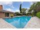 In-ground pool with brick trim, umbrella covered seating area, and lush landscaping at 906 Crestview Dr, Auburndale, FL 33823