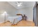 Cozy bedroom featuring vaulted ceiling, ceiling fan, wood floors, and bedside table at 915 Ashmeade Ct, Port Orange, FL 32127
