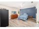 Cozy bedroom featuring stylish blue accent wall and wood-look vinyl floors at 5238 Ne 1St Ave, Ocala, FL 34479